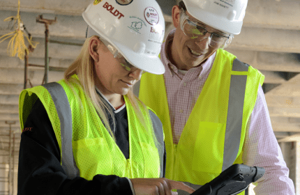 Two Construction Employees Review Item on Tablet