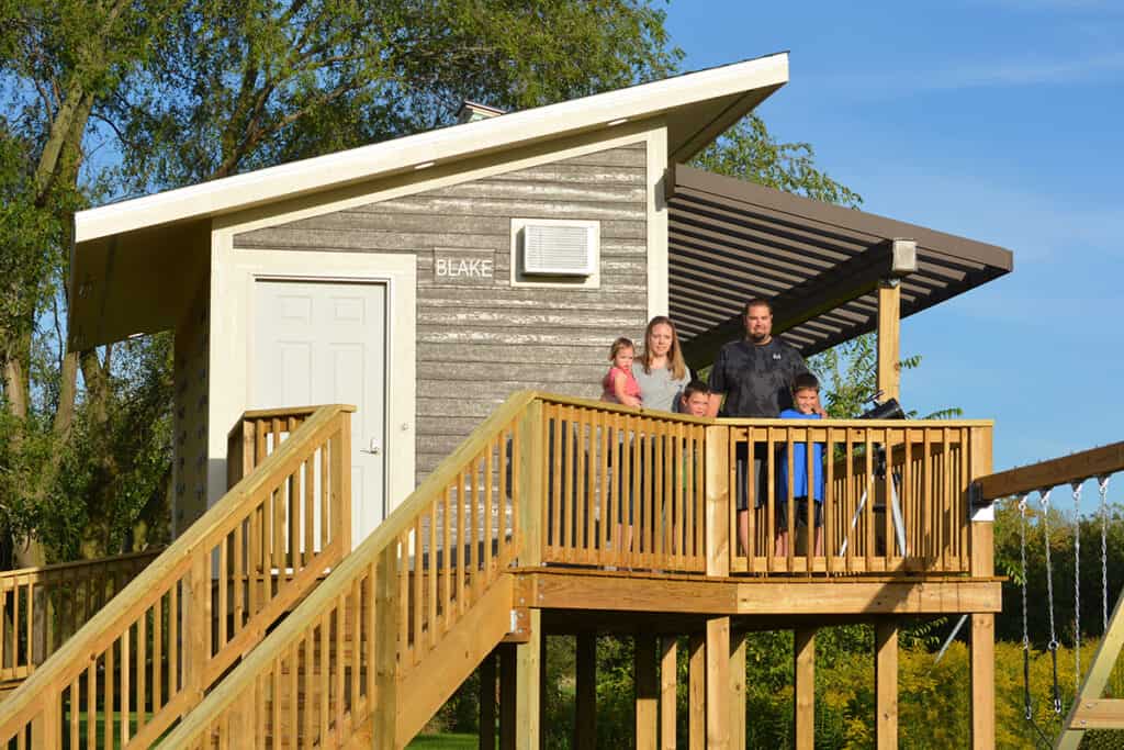 A Make-a-Wish Wisconsin family stands on a deck