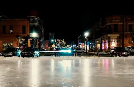 Downtown Stevens Point at night in the winter with ice rink in the center square