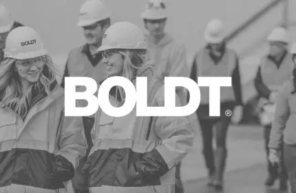 Boldt Logo on Black-and-white Image of Boldt Employees in Safety Apparel and Hard Hats