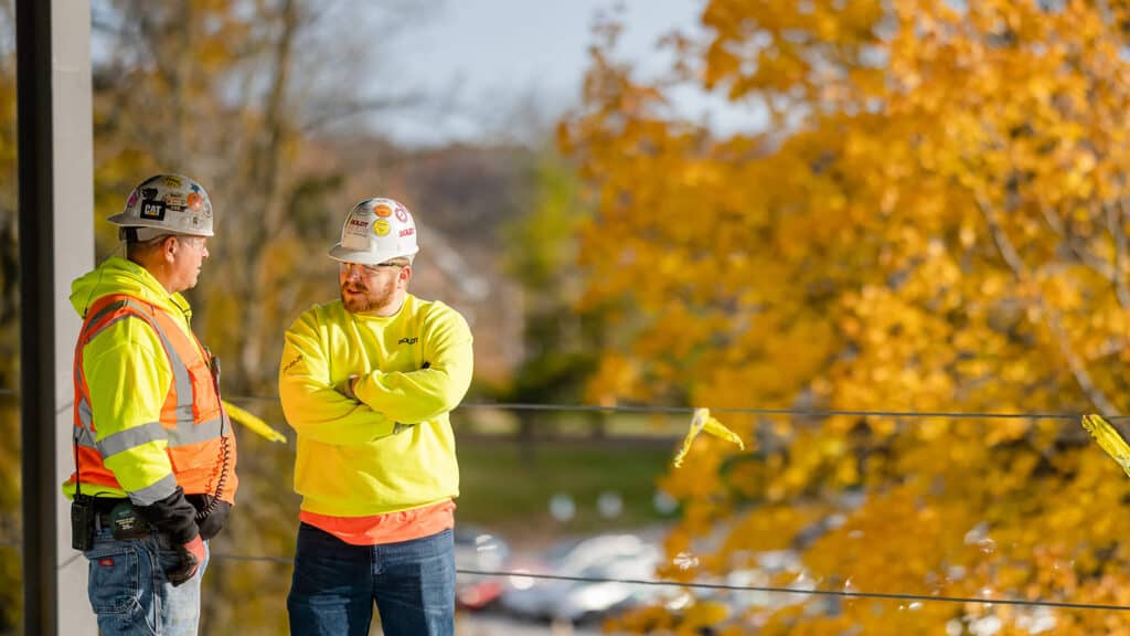 two boldt members having a conversation near an autumnal tree