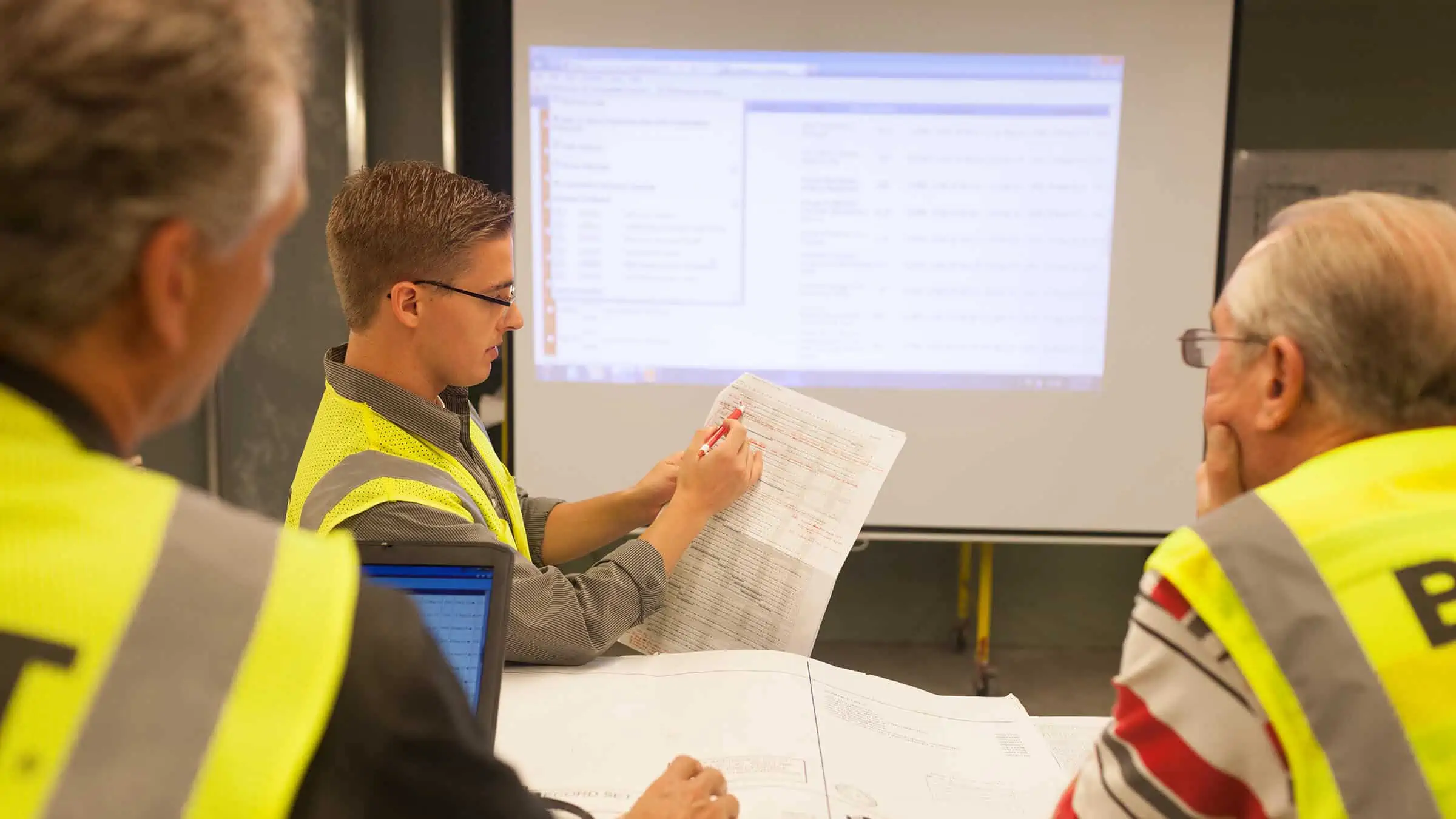 Boldt team members discussing with two co-workers while showing a presentation on screen