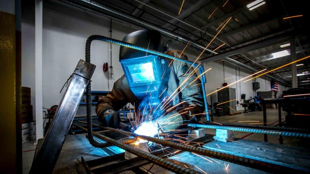 Welder at work, wearing welding helmet