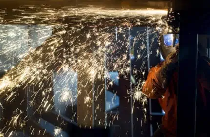 Welder at work with sparks coming off weld site