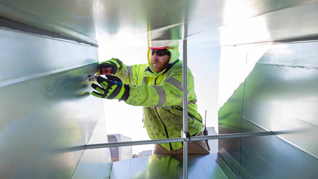 Construction worker doing emergency repairs on heating ducts