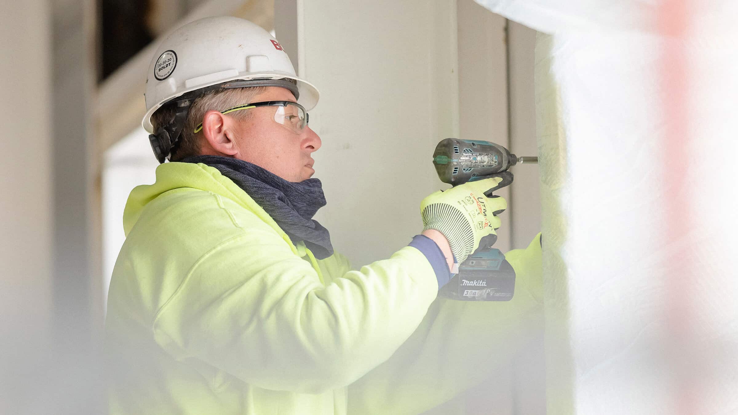 Construction Worker Using Drill to Install Drywall