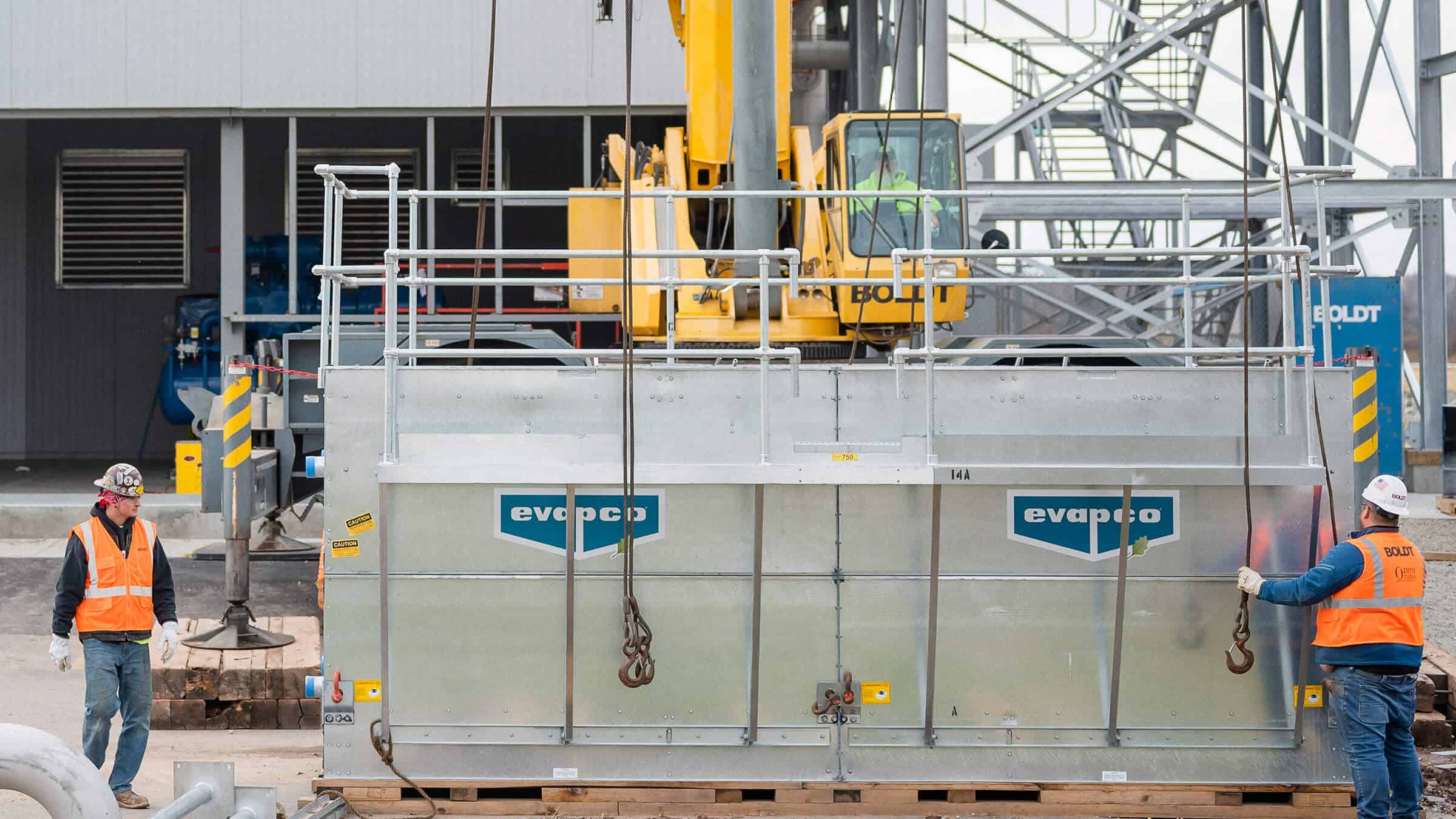 Boldt Technical Services - construction workers preparing to hoist equipment for equipment installation using a crane