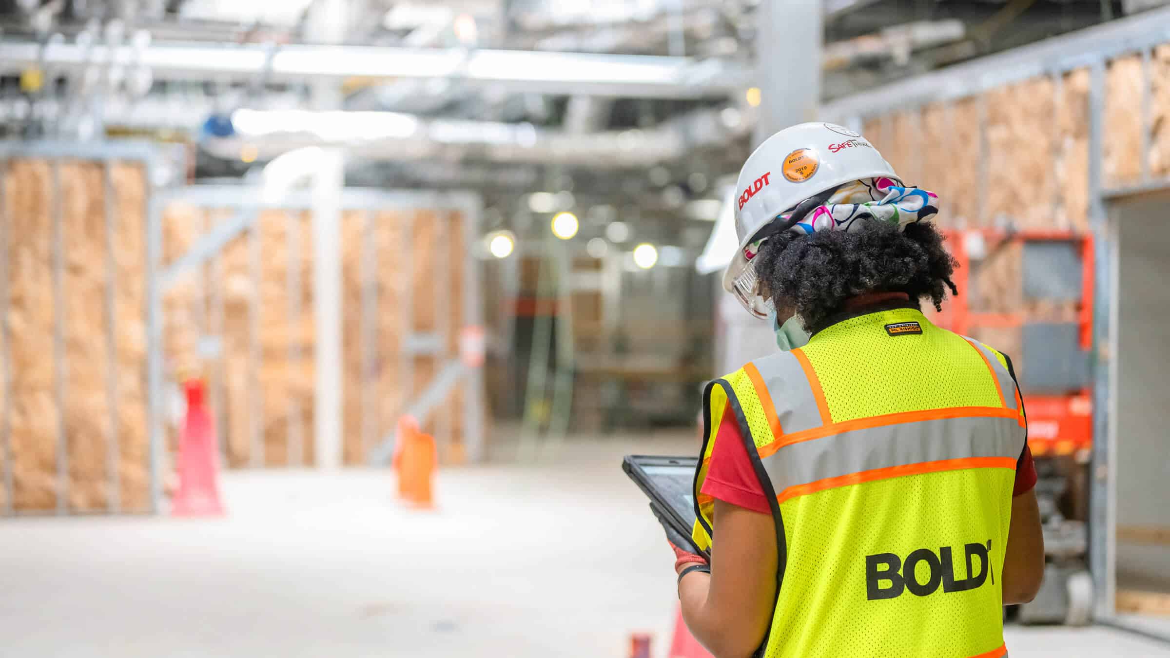 Construction worker checks installation of modular units on tablet