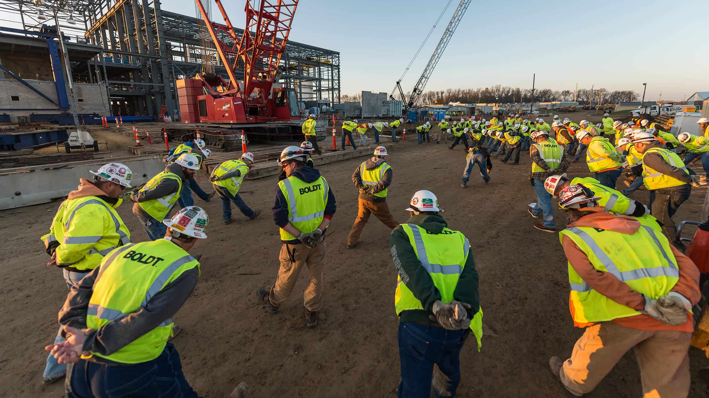 Construction workers stretching for safety in morning at jobsite