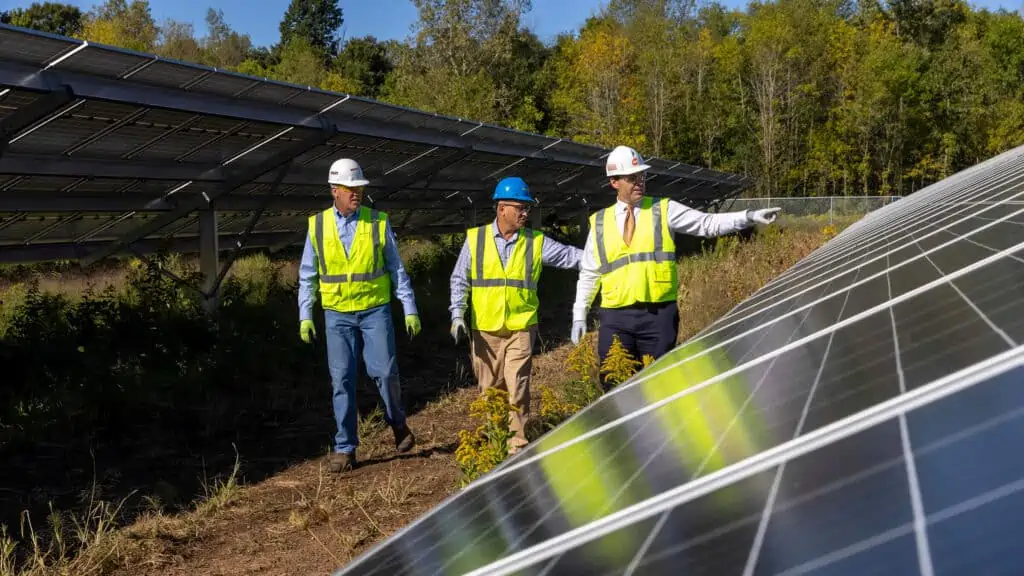 three construction managers inspecting solar panels