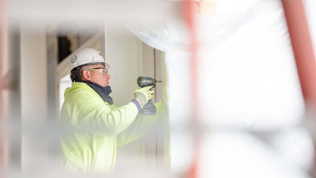 Construction worker using drill on job site