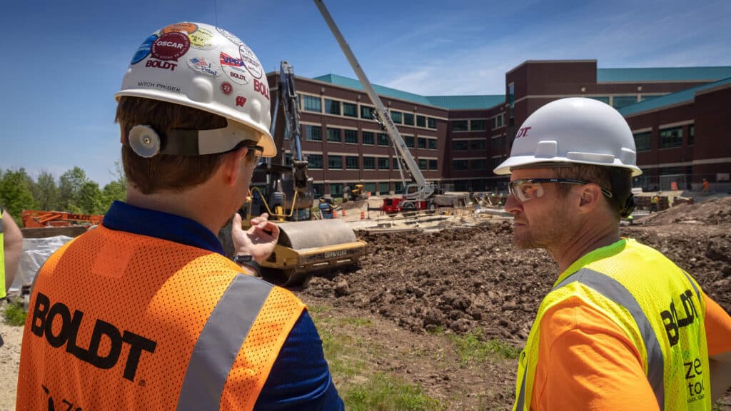 two construction workers assessing job site