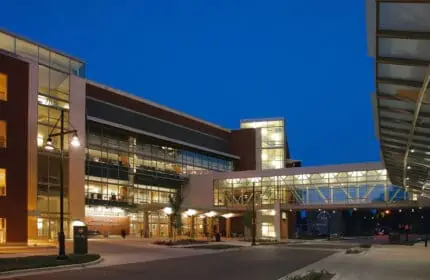 SSM Health - St. Mary's Hospital Campus - Outpatient Center and Parking and Exterior View of Building at Dusk with Skyway Connecting Two Buildings Lit