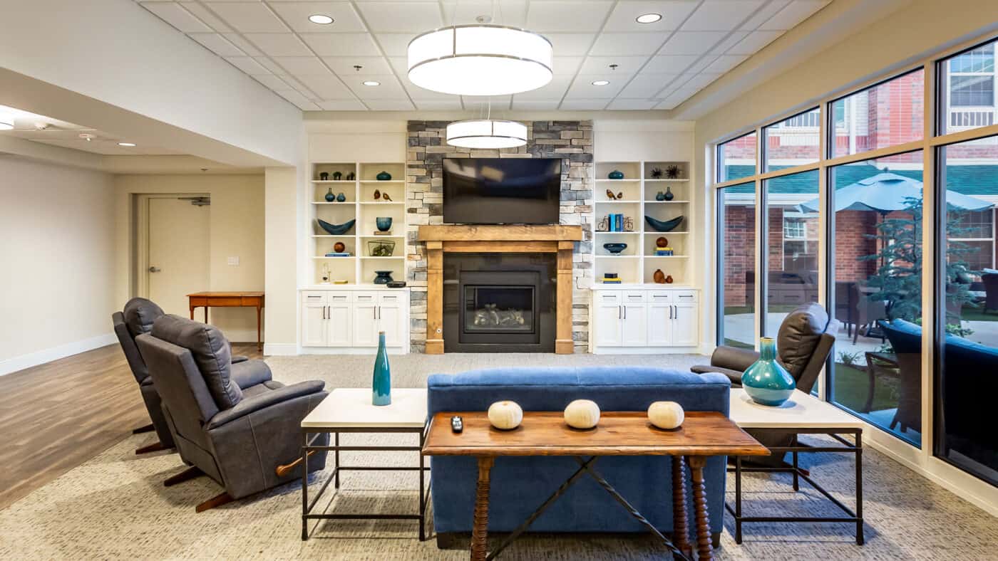 Spanish Cove Retirement Community Seating with Fireplace and Soft Seating, View to Exterior