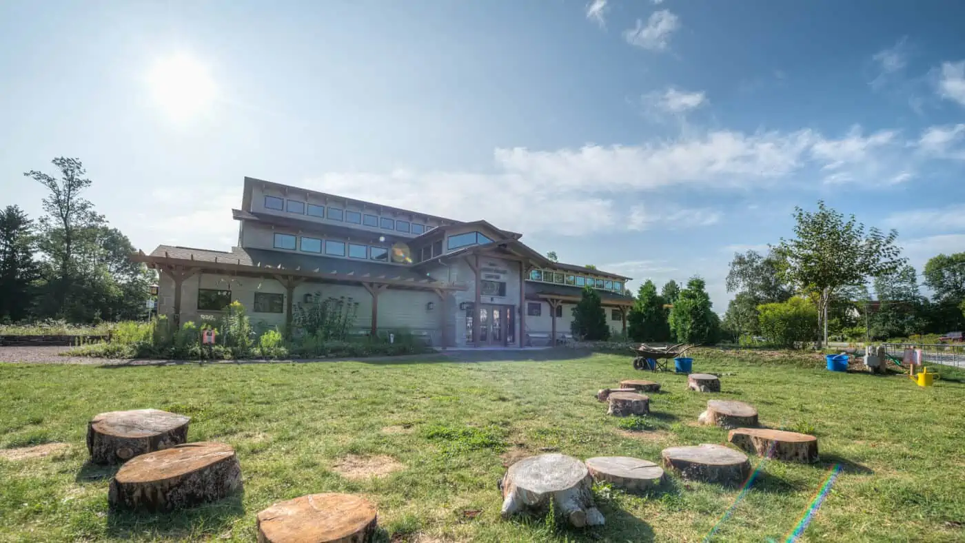 The Ridges Sanctuary - Center for Environmental Stewardship Exterior View of Building with Tree Stump Seating Visible on Lawn