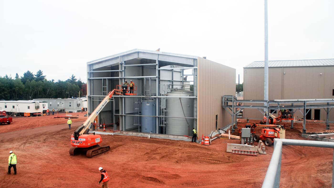 UMERC - Generating Station - Exterior of Construction Site with Workers on Lift Outside Building