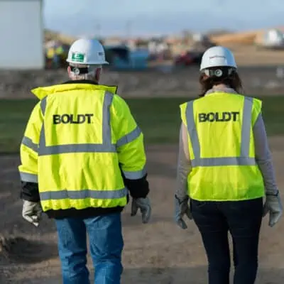 Two People Walk in Boldt Safety Vests