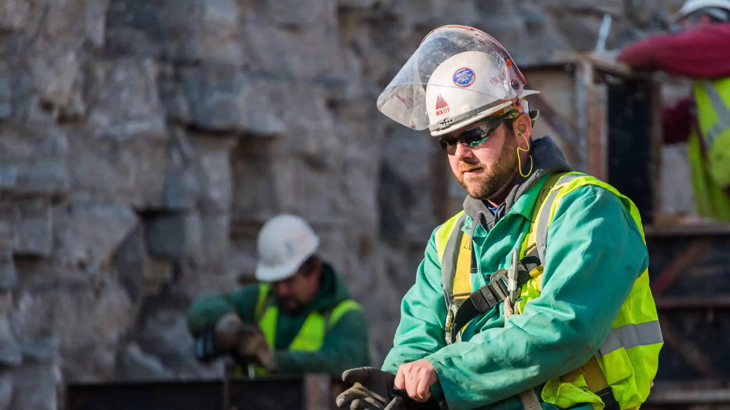 Construction worker on job site in hard hat with face shield up