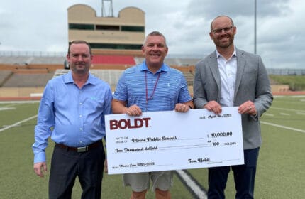 Boldt Oklahoma City employees hold oversized check to Moore Public Schools